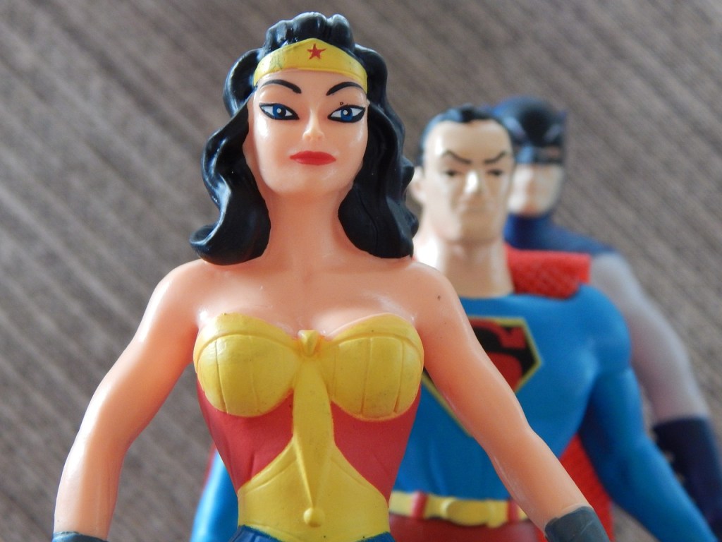 wonder woman doll standing in front of superman doll
